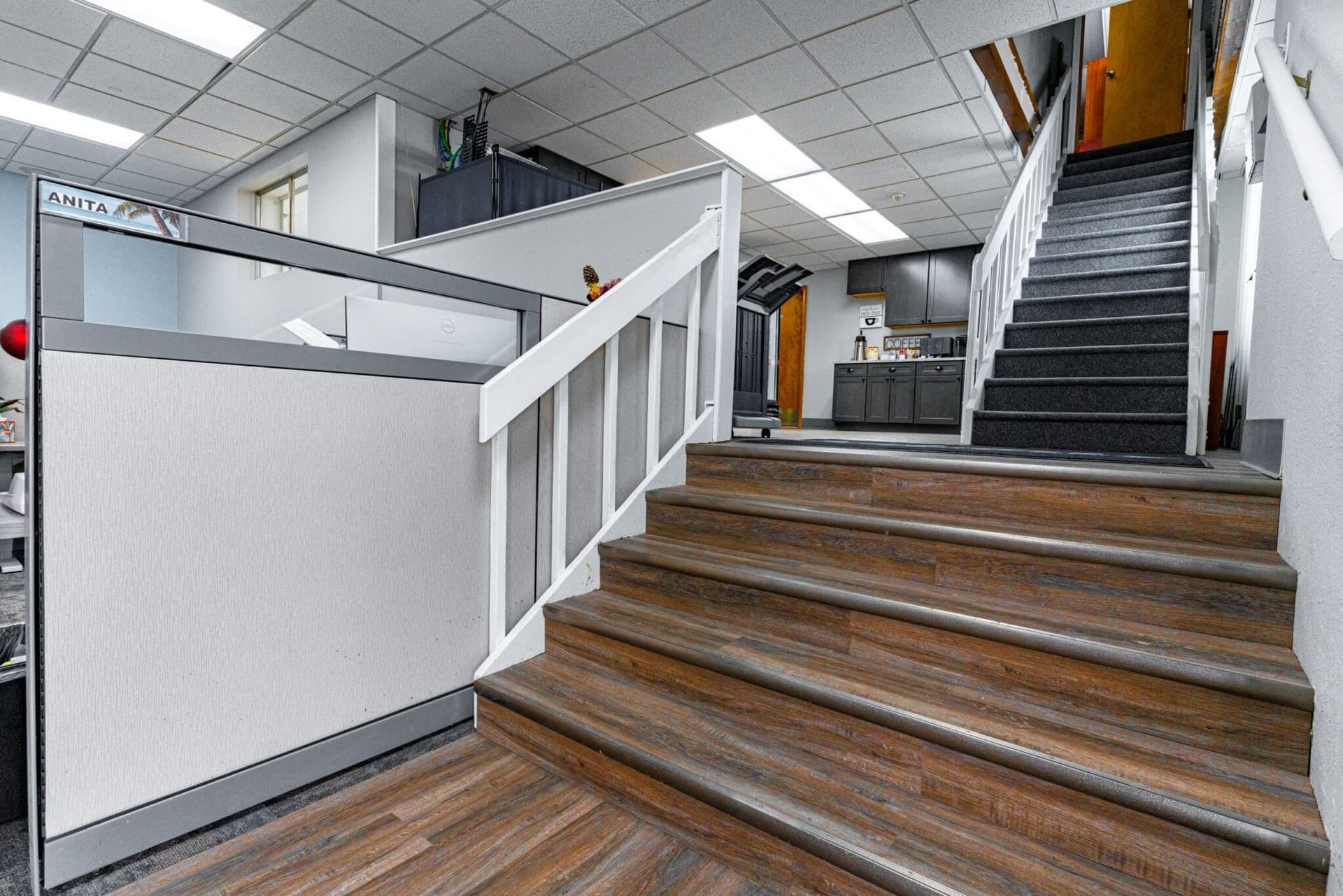 Wood-finished stairs and upper-level railings inside a commercial space
