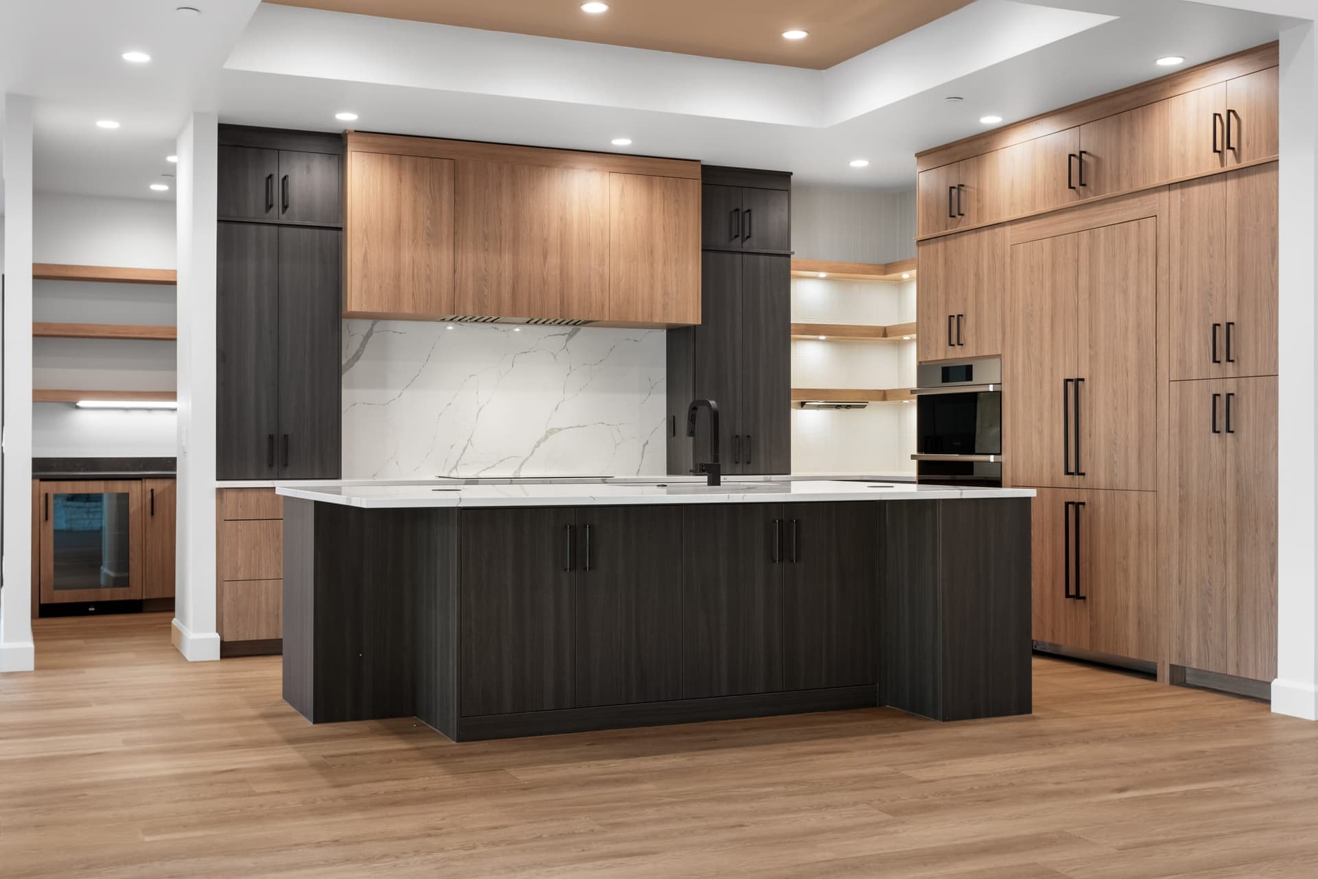 Kitchen with a dark island, wood cabinets and recessed lighting