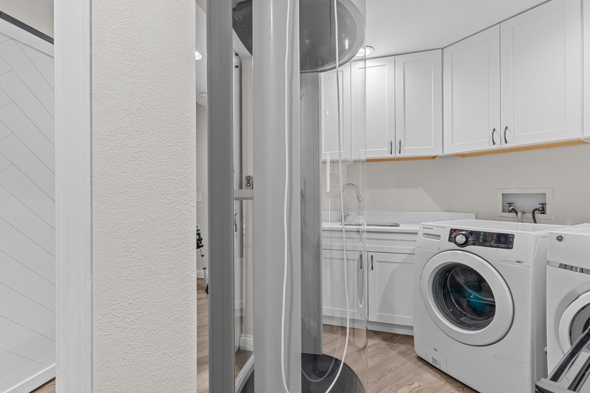 Custom elevator access beside finished utility room cabinetry