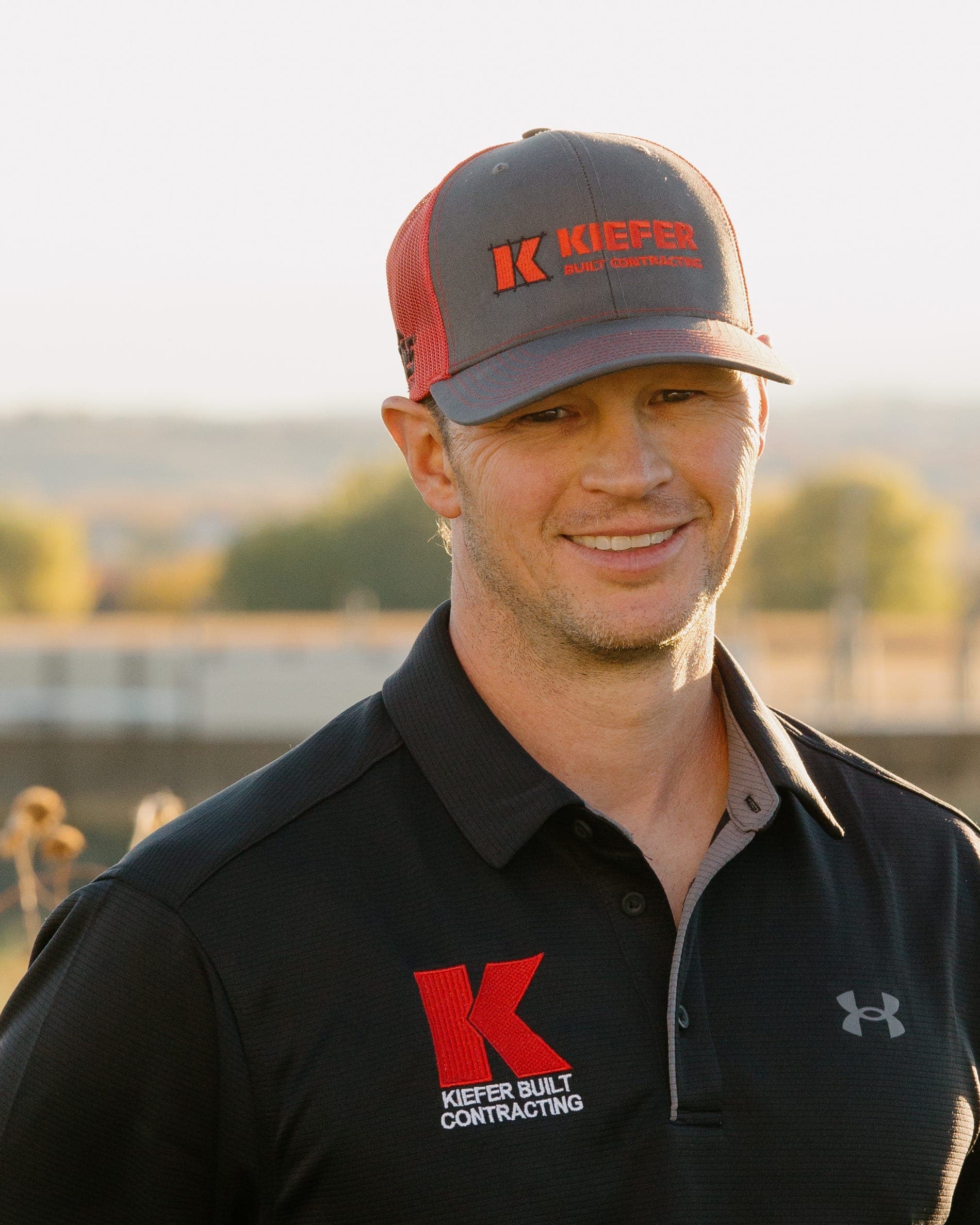 Miles Kiefer wearing a Kiefer Built shirt and cap outdoors
