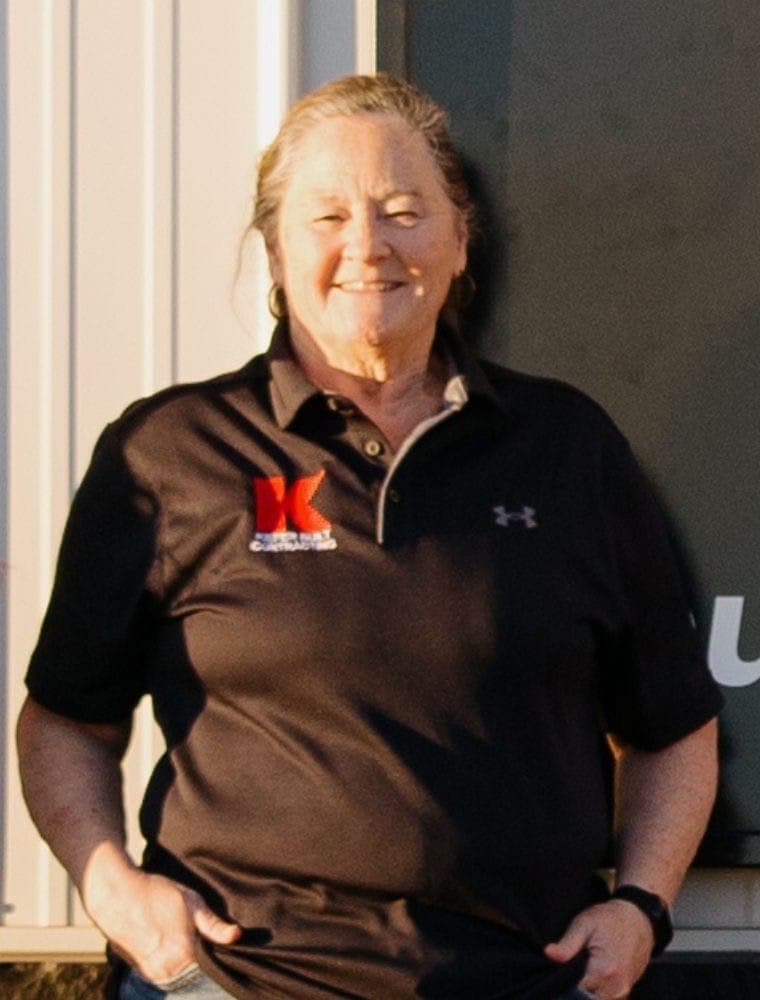 Mindy Kiefer wearing a Kiefer Built shirt beside a doorway