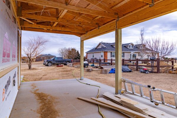 New build. Framing of a porch with a view of the main house.