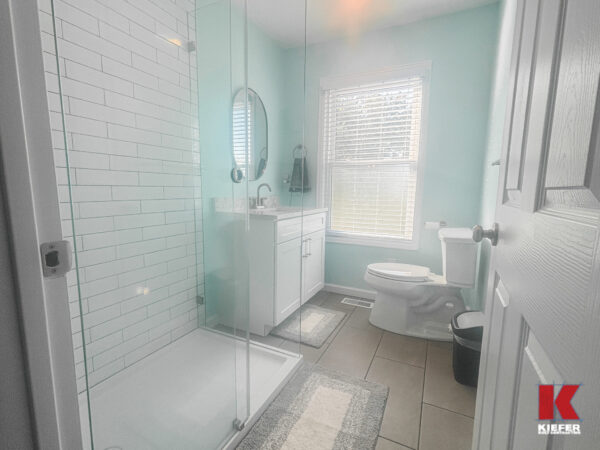 renovated bathroom space featuring tile and glass shower.