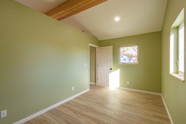 Efficient new build with exposed beams, hardwood floors, and versatile bedroom or office space.