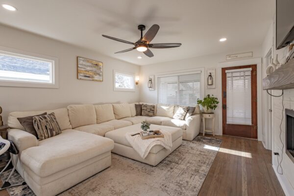 Renovated living room with hardwood floors, fireplace, and mantel.