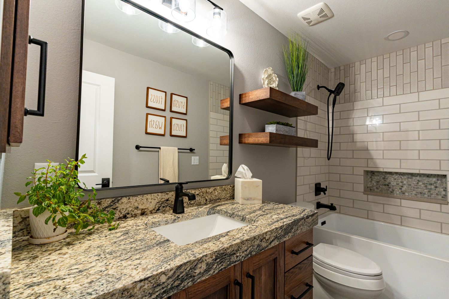 Elegant, functional bathroom in a renovated home with wood cabinetry and stylish lighting and features.